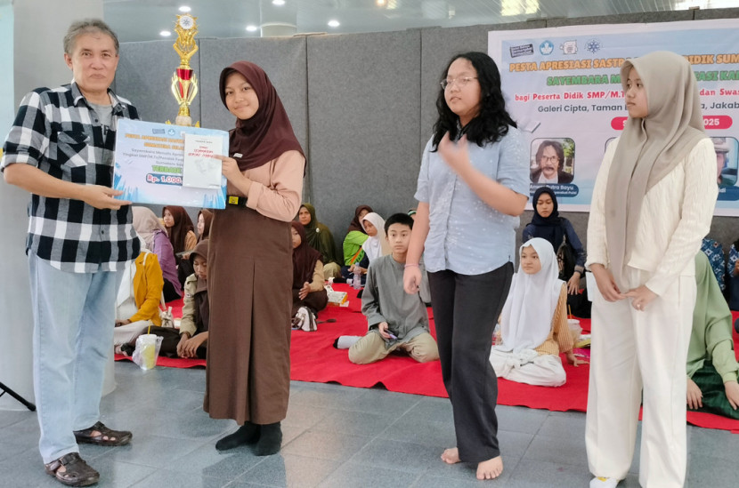 Maspril Aries juri lomba menulis puisi menyerahkan hadiah kepada pemenang. (FOTO: Erfan Fajrullah)