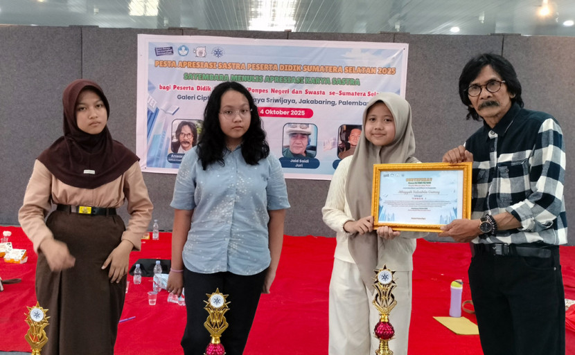 Anwar Putra Bayu Ketua Koalisi Masyarakat Puisi menyerahkan sertifikat kepada pemenang. (FOTO: Maspril Aries)