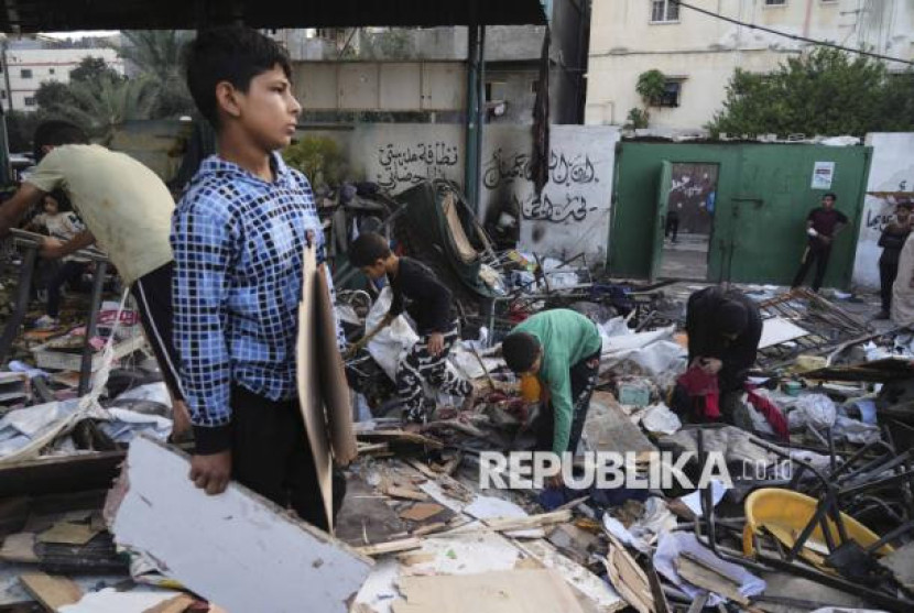 Anak-anak Gaza melihat bangunan sekolah yang hancur akibat serangan militer Israel.
