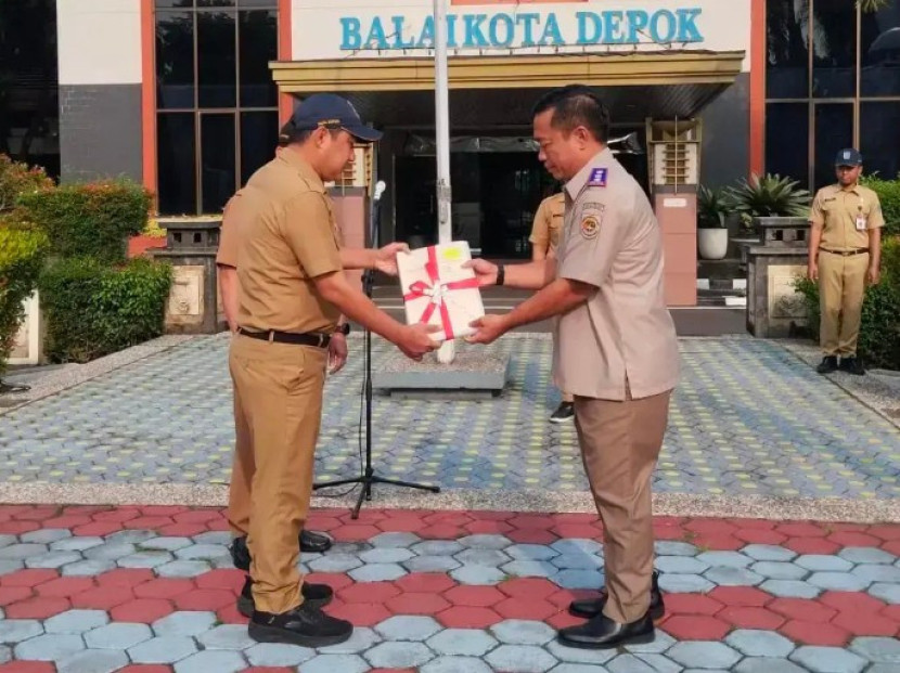 Kepala Kantor BPN Kota Depok, Budi Jaya menyerahkan sertipikat elektronik kepada Wakil Wali Kota Depok, Chandra Rahmansyah. (Foto: Dok Diskominfo Kota Depok) 