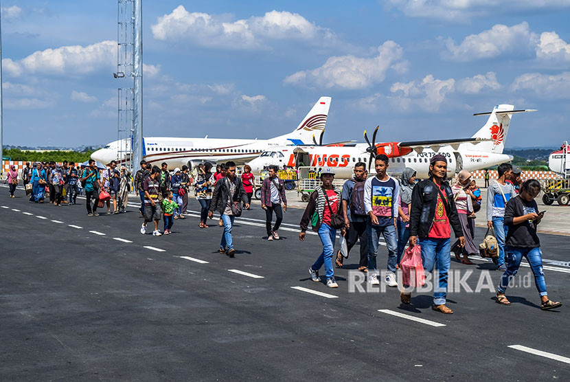 Para penumpang pesawat tiba di bandara tujuan.