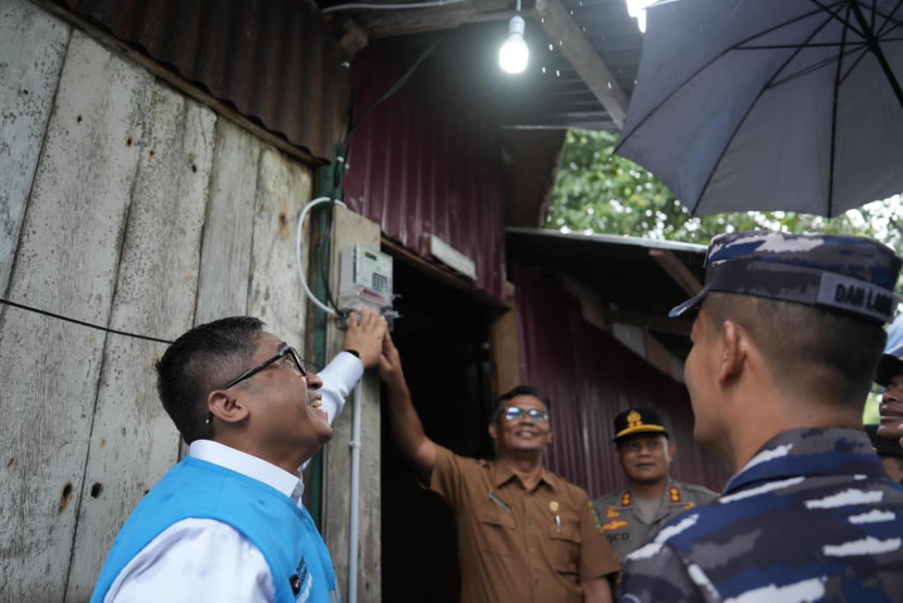 Direktur Perencanaan Korporat dan Pengembangan Bisnis PLN, Hartanto Wibowo (kiri) menyalakan sambungan listrik di salah satu rumah penerima manfaat program