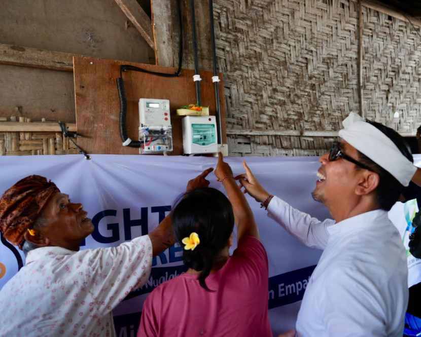 Simbolis penyalaan listrik program Berbagi Cahaya, Menumbuhkan Harapan”oleh Wakil Walikota Denpasar, I Kadek Agus Arya Wibawa (kanan) bersama penerima manfaat, I Nyoman Nuki (kiri) dan Made Rasmi di Sesetan, Denpasar, Senin (21/10/2025). (Foto: PLN)
