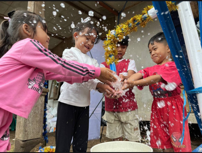 Anak-anak bahagia memiliki sumur air bersih