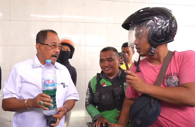 Armuji menunjukkan botol berisi cairan dua warna saat sidak di SPBU Rajawali, Surabaya