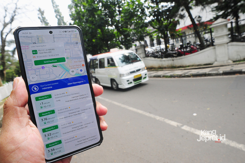 Layar ponsel menunjukkan posisi sejumlah armada Feeder MJT dengan latar angkot pintar tersebut saat melintasi Jl Cilaki Bandung, Jumat (31/10/2025). Keberadaan Feeder MJT dapat dipantau melalui maps secara real time pada aplikasi Mitra Darat.KANGJEPRET.ID/ YOGI ARDHI (Data: Nikon D700, Nikkor 20/2.8 D)