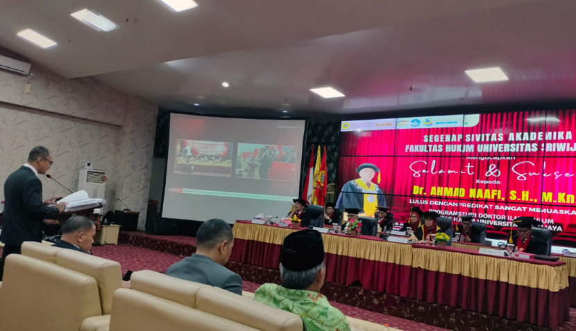 Ahmad Naafi (kiri) saat ujian terbuka dan dinyatakan lulus sebagai doktor Ilmu Hukum Kepemiluan. (FOTO: Maspril Aries)