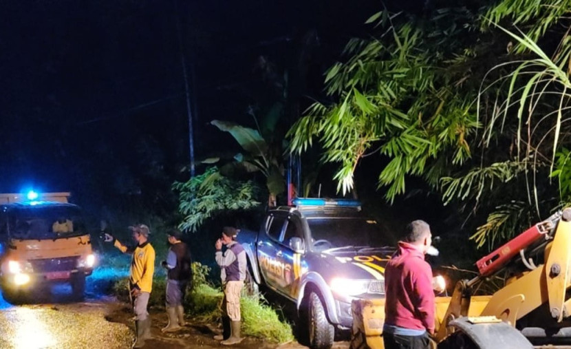 Personel Polsek Banjarwangi, warga dan petugas PUPR membersihan material longsor menimpa badan jalan raya Banjarwangi – Cikajang. (Foto: Dok Ridwan)