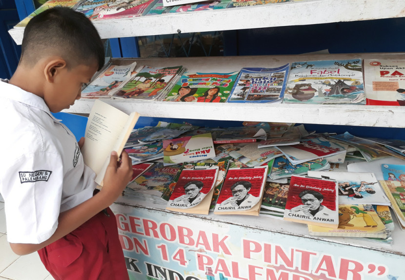 Tertular visur baca, Siswa SDN 14 Palembang membaca buku puisi Chairil Anwar. (FOTO: Maspril Aries)