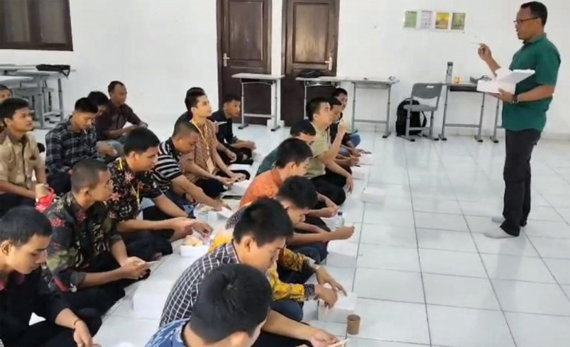 Pelatih mengajarkan cara menggunakan sumpit. (FOTO: Dok. Disnakertrans)