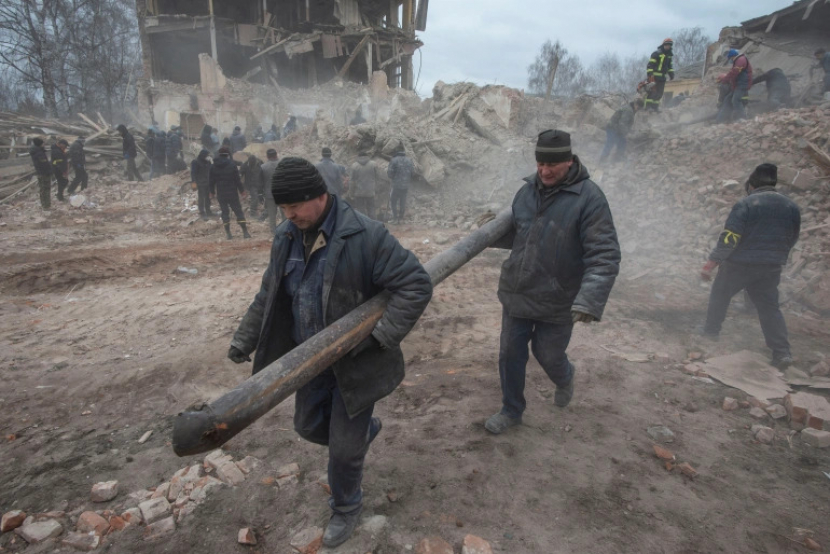 Orang-orang membuang puing-puing di lokasi sebuah bangunan pangkalan militer di wilayah Sumy [File: Irina Rybakova/Layanan pers dari pasukan darat Ukraina/Handout/Reuters]