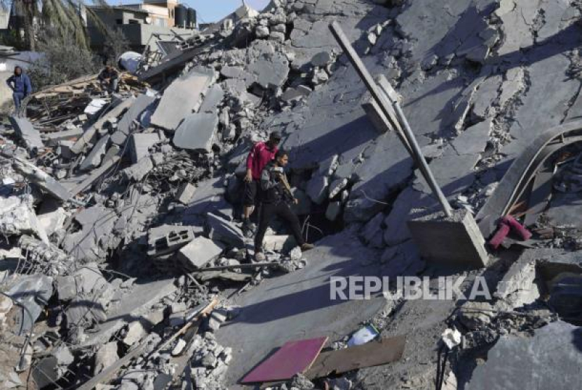 Warga Palestina mencari korban selamat setelah serangan udara Israel yang menargetkan bangunan keluarga Rayan di kamp pengungsi Nusseirat, Gaza, Kamis (15/2/2024).   