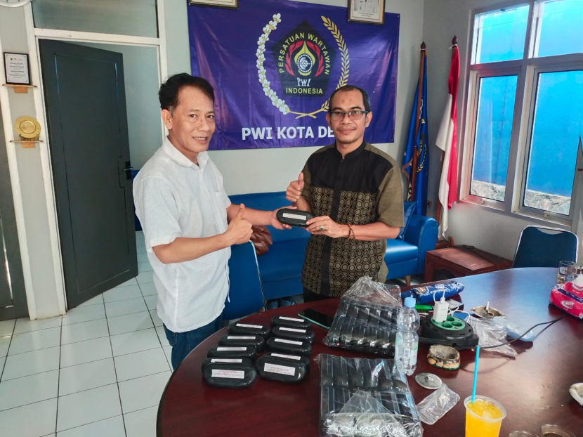 Ketua PWI Kota Depok, Rusdi Nurdiansyah menyerahkan kacamata yang merupakan bantuan dari Optik Sejahtera Depok kepada anggota PWI, Rabu (13/12). 