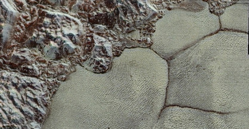 Dari dekat pegunungan air-es di pinggiran barat laut gletser Sputnik Pluto mungkin menyediakan partikel, dan jantung nitrogen Pluto yang berdenyut menyediakan angin. Kredit: NASA/JHUAPL/SwRI