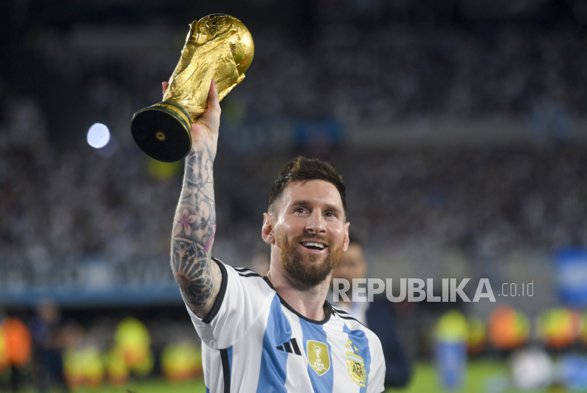 Penyerang tim nasional Argentina, Lionel Messi saat mengangkat trofi Piala Dunia 2022 di Qatar