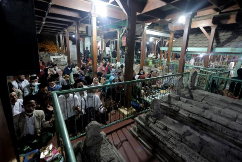 Peziarah memanjatkan doa saat tradisi malam selawe di Makam Sunan Giri, Gresik, Jawa Timur, Selasa (26/4/2022). Foto: ANTARA/Rizal Hanafi