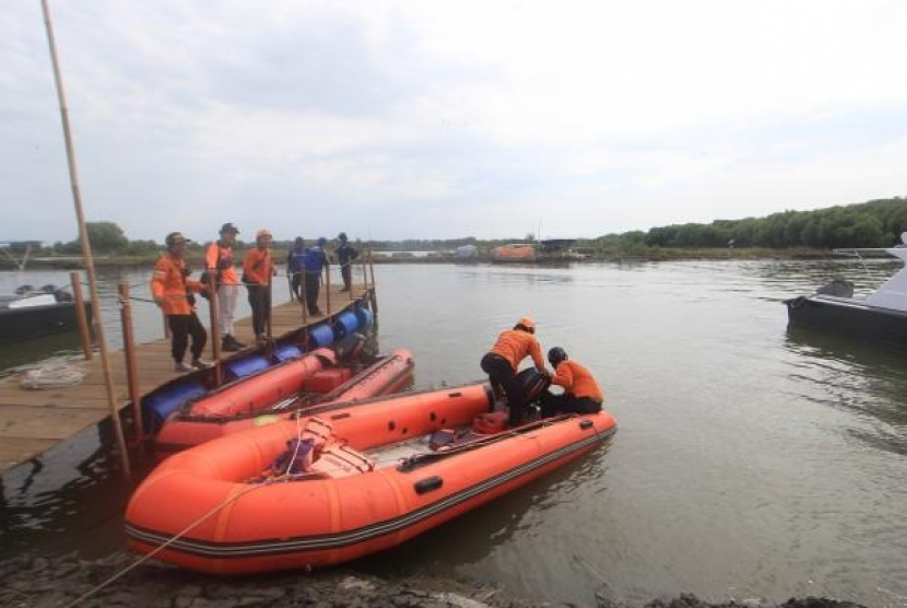 Personel BPBD mengawasi perahu saat pencarian nelayan akibat kapal motornya tenggelam akibat diterjang gelombang setinggi dua meter. (ANTARA /Dedhez Anggara)