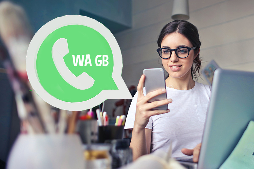 Wanita pegang HP di sebelah logo GB Whatsapp terbaru 2022.