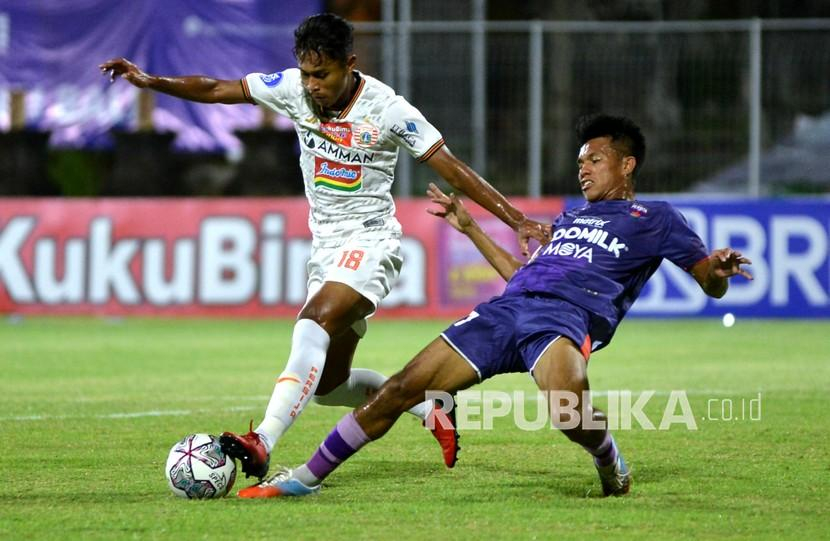 Pesepak bola Persija Jakarta Alfriyanto Nico Saputro (kiri) berebut bola dengan pesepak bola Persita Tangerang Muhamad Kasim Botan (kanan) saat pertandingan Liga 1 di Stadion I Gusti Ngurah Rai, Denpasar, Bali, Rabu (26/1/2022). 