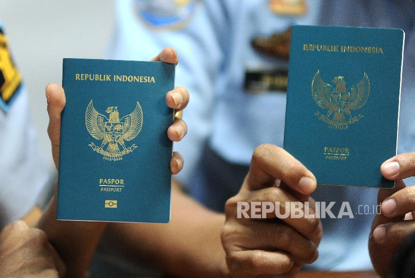 Petugas menunjukkan paspor biasa elektronik atau e-paspor dan paspor biasa nonelektronik. (Antara/Fikri Yusuf)