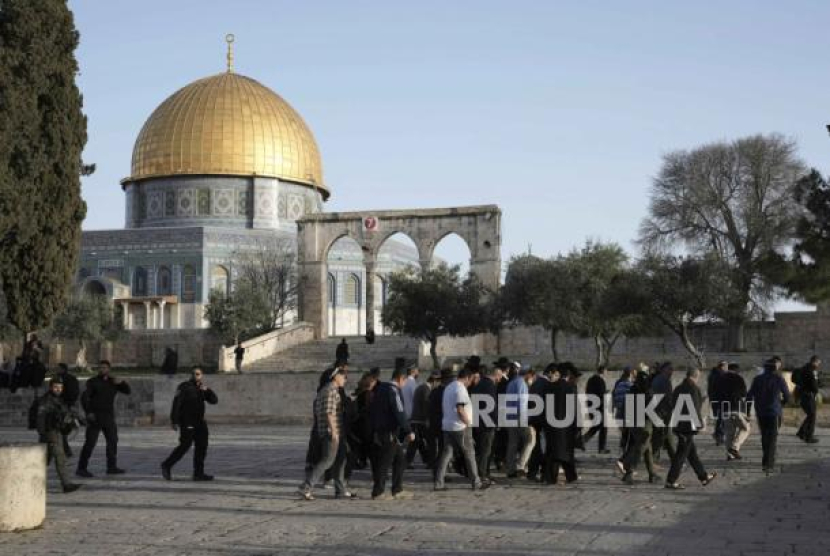  Polisi Israel mengawal pengunjung Yahudi yang menandai hari raya Paskah ke kompleks Masjid Al Aqsa, yang dikenal oleh umat Islam sebagai Tempat Suci Mulia dan bagi orang Yahudi sebagai Temple Mount, menyusul penggerebekan di situs tersebut, di Kota Tua Yerusalem pada bulan suci Ramadhan, Rabu (5/4/2023). Serangan Israel: Dimana Masjid Al Aqsa dan Mengapa Begitu Penting Bagi Dunia Islam? Foto: AP Photo/Mahmoud Illean