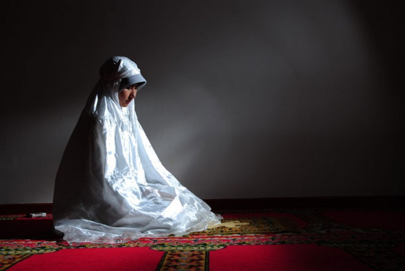 Seorang Muslimah sedang melaksanakan Sholat. Rasulullah melarang seorang Muslim sholat di atas kuburan. Foto: Republika.