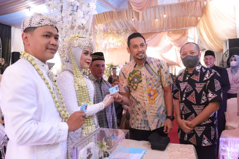 Wabup Kuningan, M Ridho Suganda, menyerahkan KTP baru kepada pasangan pengantin. (Dok Diskominfo Kabupaten Kuningan)