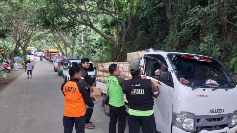 Laznas BMH memberikan bantuan makanan, suplemen, air mineral, kue dan makanan lainnya kepada pengguna jalan yang terhambat akibat longsor di Desa Onang, Kabupaten Majene, Sulawesi Barat. (Foto: Dok BMH)