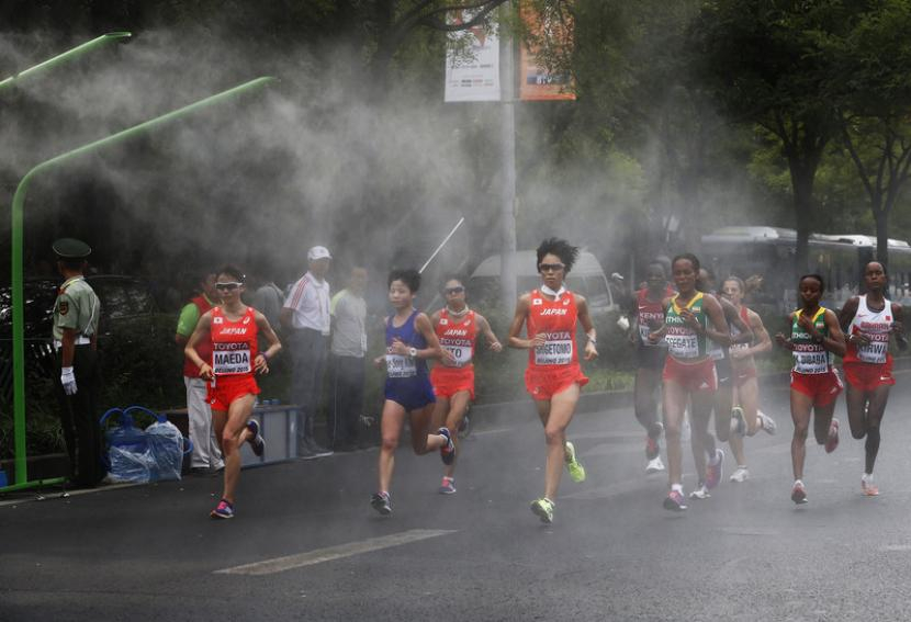 Peserta berlari di tengah kabut dalam lomba maraton Kejuaraan Dunia IAAF Beijing 2015 di National Stadium alias Bird's Nest, di Beijing, China, 30 Agustus 2015. Foto: EPA