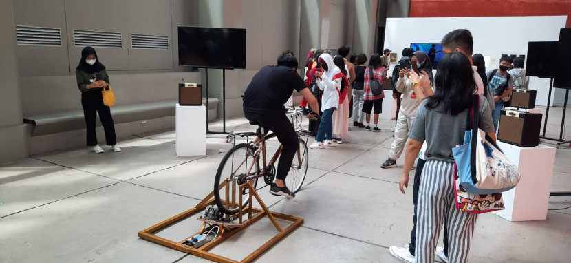 Pengunjung mencoba sepeda statis yang hasil kayuhannya bisa menjadi energi yang menghidupkan lampu di depannya