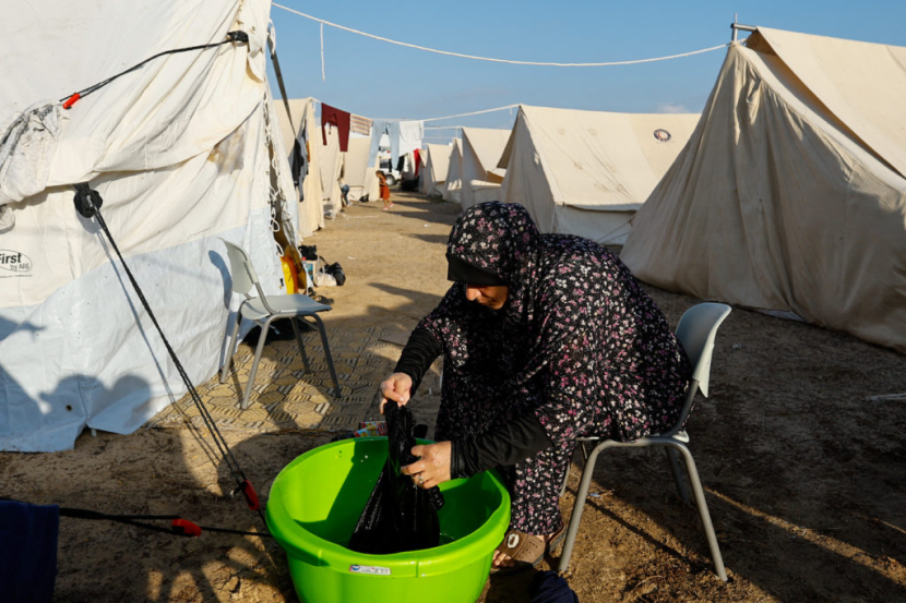 Pengungsi Gaza mencuci pakain di depan tendanya.