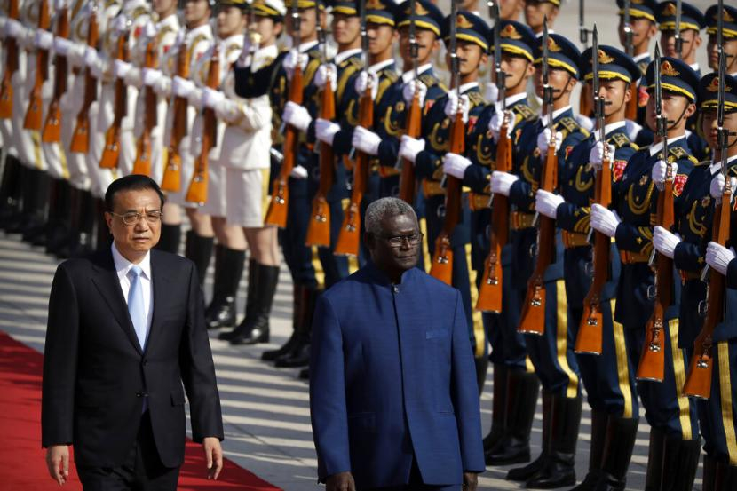 Perdana Menteri Cina Li Keqiang, kiri, dan Perdana Menteri Solomon Islands Manasseh Sogavare meninjau pengawal kehormatan saat upacara penyambutan di Aula Besar Rakyat di Beijing, Rabu (9/10/2019). Foto: AP Photo/Mark Schiefelbein (Republika.co.id)