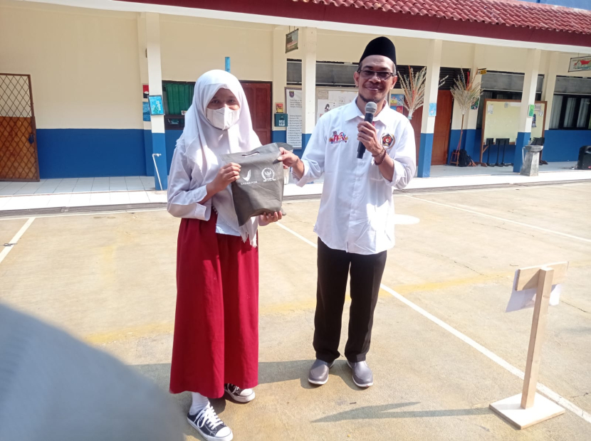 Seorang siswa mendapatkan hadian Tumbler dari pemateri.