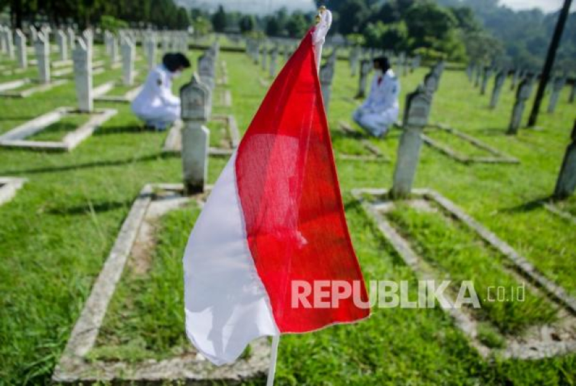 Dua anggota Paskibraka Kota Bandung melakukan tabur bunga saat ziarah Peringatan Ke-75 Peristiwa Bandung Lautan Api di Taman Makam Pahlawan Cikutra, Bandung, Jawa Barat, Selasa (23/3/2021). Pemerintah Kota Bandung menggelar ziarah dengan protokol kesehatan untuk tetap mengenang dan menjaga jasa para tentara dan penduduk sipil saat peristiwa Bandung Lautan Api pada 1946 dalam membela Indonesia dari penjajah Sekutu dan NICA. Foto: Antara/Novrian Arbi 