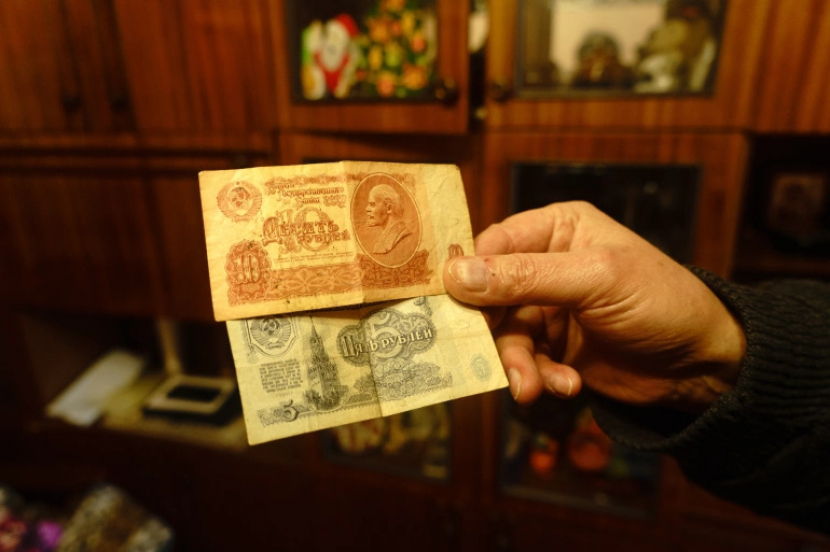 Valeriy Dzyubinskiy di rumahnya menunjukkan koleksi uang rubel Sovietnya.KrasnohorivkaValeriy Dzyubinskiy memamerkan koleksi rubel Sovietnya di Krasnohorivka, Ukraina [Emre Caylak/Al Jazeera]