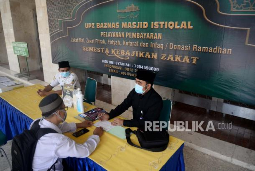 Petugas Amil Zakat memberikan informasi kepada warga yang hendak membayar fidyah. (Dok. Republika)