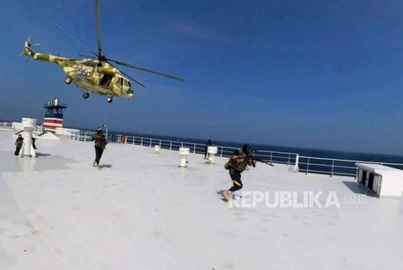 Foto selebaran yang disediakan oleh pusat media Houthi menunjukkan sebuah helikopter yang dioperasikan Houthi terbang ketika para pejuang Houthi berlari di dek kapal kargo Galaxy Leader yang direbutnya di Laut Merah, lepas pantai Hodeidah, (20/11/2023).
