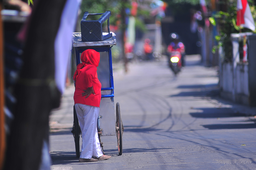 Seorang ibu penjual makanan mengenakan pakian bernuansa merah putih menikmati suasana sore di Jalan Haji Bardan, Bandung, Sabtu (17/8/2024). (Foto Yogi Ardhi/Republika Network) (Nikon D3, Nikkor 300/2.8 Ai MF).