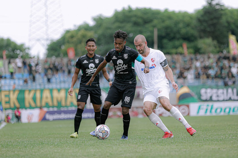 Pemain Persebaya Alwi Slamat ditempel ketat Pemain PSM Makassar Wiljan Pluim. Sumber: persebaya.id 