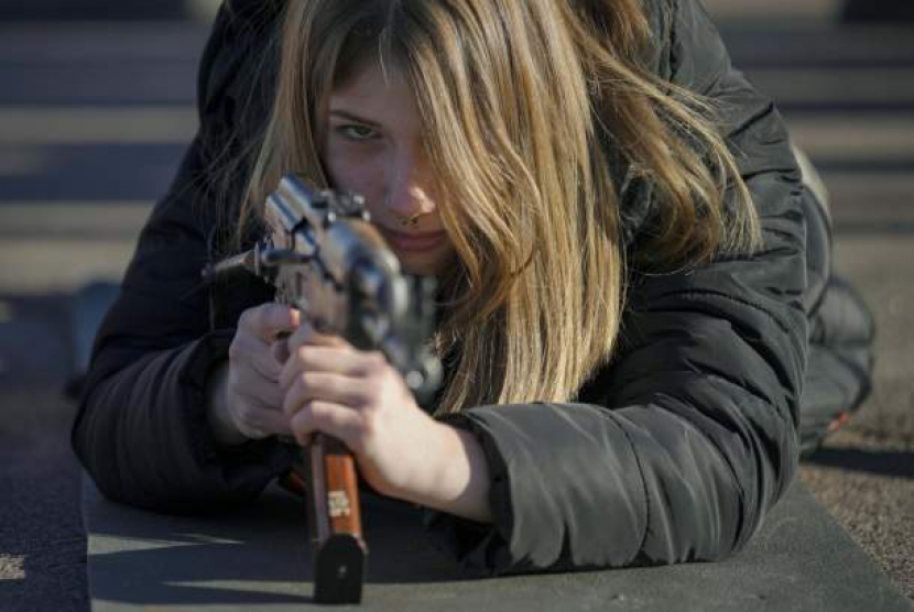 Seorang perempuan berlatih menggunakan senjata di Mariupol, Donetsk, Ukraina, Ahad (13/2/2022). Pelatihan itu guna mengantisipasi serangan Rusia. - (AP/Vadim Ghirda)