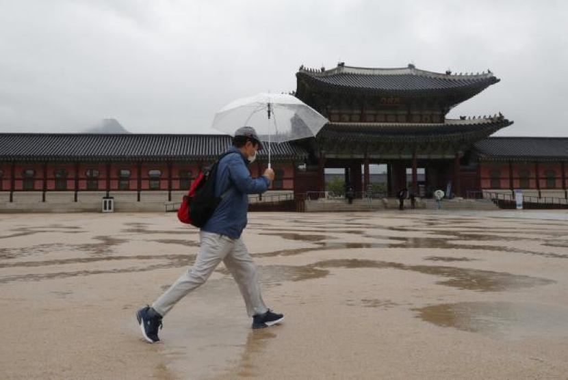 Seorang warga melintas di Gyeongbok Palace di Seoul, Korea Selatan. Foto: AP Photo/Lee Jin-man