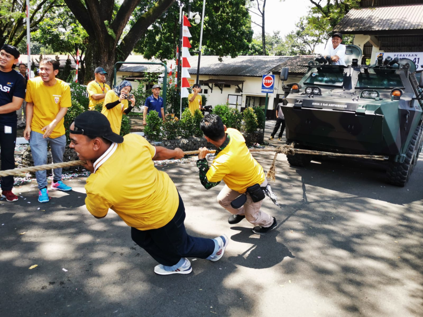 Staf Divisi PT Pindad berusaha menarik Panser Anoa 6x6 buatan Pindad pada saat lomba Tarik Panser di sela peringatan HUT ke-41 PT Pindad di Bandung, Senin (29/4/2024).