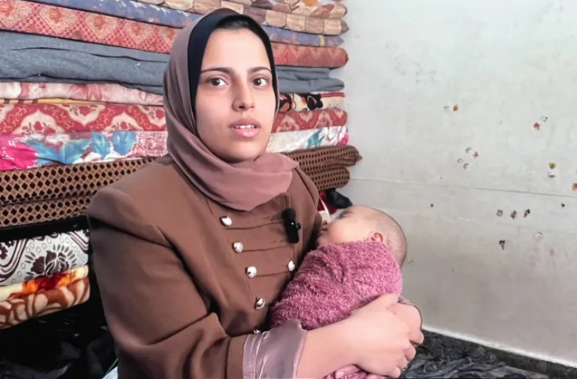 Mata Um Raed penuh kekhawatiran terhadap bayi laki-lakinya [Sanad Agency/Al Jazeera]