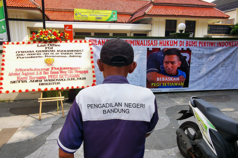 Petugas Kantor Pengadilan Negeri Bandung tampak memperhatikan spanduk dan karangan bunga berisi dukungan bagi Pegi Setiawan di depan kantor PN Bandung, Jl Martadinata, Bandung, Senin (8/7/2024).