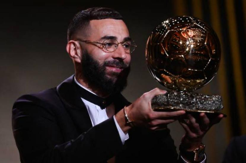 Karim Benzema mengangkat trofi Ballon d'Or 2022.