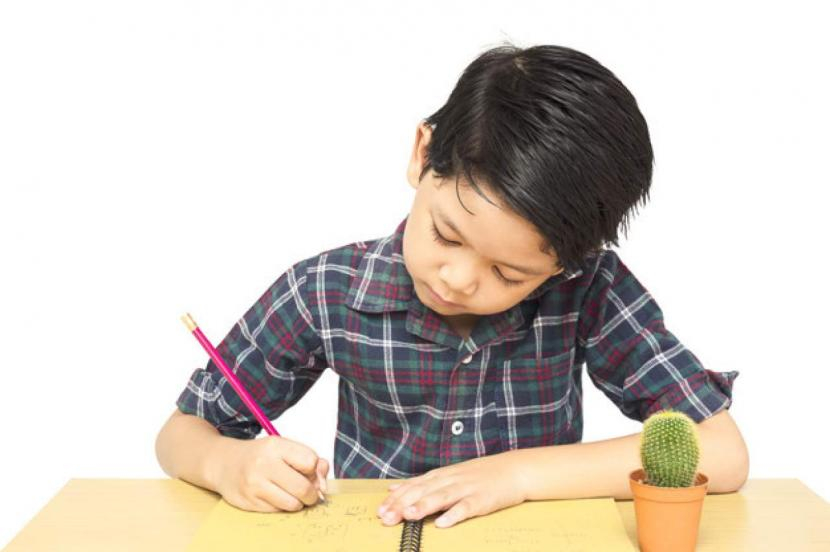 Seorang anak sedang menulis di atas buku catatan. Perbedaan Fonologi, Morfologi, Sintaksis dan Semantik dalam Ilmu Linguistik (ilustrasi). Dok. Istimewa