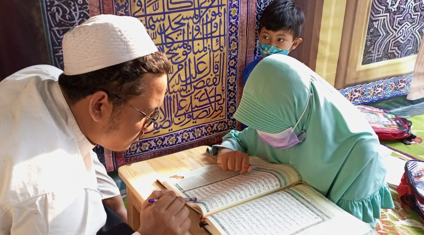 Seorang guru sedang mengajari santri membaca Al-Quran. (dok. Rumah Berkah)