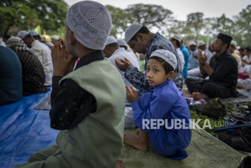 Seorang anak laki-laki melihat yang lain saat umat Islam melaksanakan sholat Idul Fitri di Gauhati, India, Selasa, 3 Mei 2022. Lakukan Cara Ini Agar Si Kecil Siap Sambut Ramadhan. Foto: AP/Anupam Nath