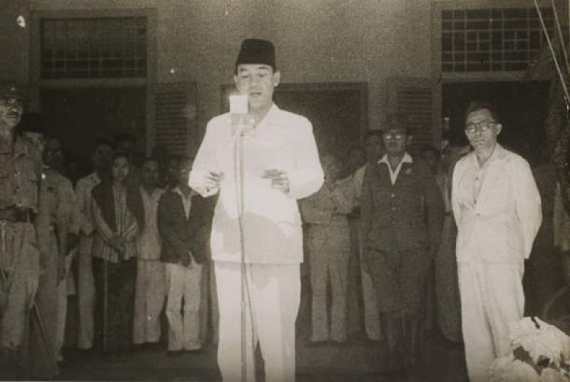 Pembacaan Teks Proklamasi. Soekarno didampingi Hatta membacakan naskah proklamasi pada 17 Agustus 1945.