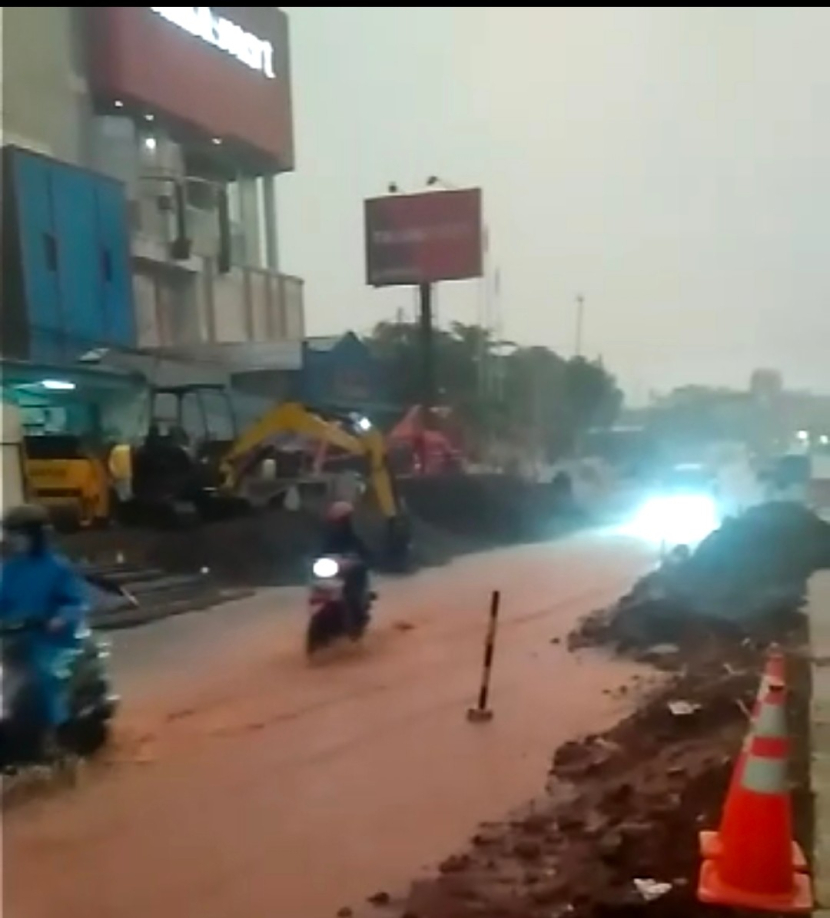 Dampak dari proyek underpass Dewi Sartika Depok, lingkungan banjir dan tanah merah dibiarkan berserakan dan menumpuk di pinggir jalan.